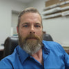 Man with a beard wearing a blue shirt in an indoor setting