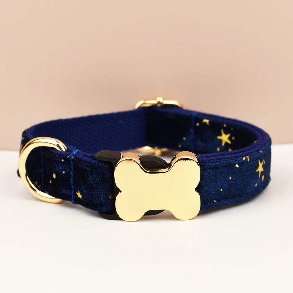 Navy blue dog collar with gold bone-shaped tag on a beige background