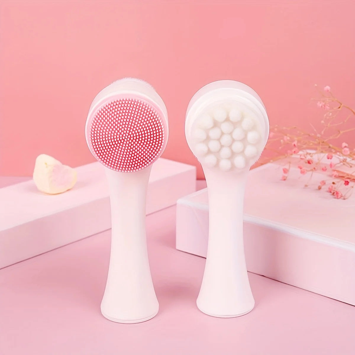 Two facial cleansing brushes on a pink background